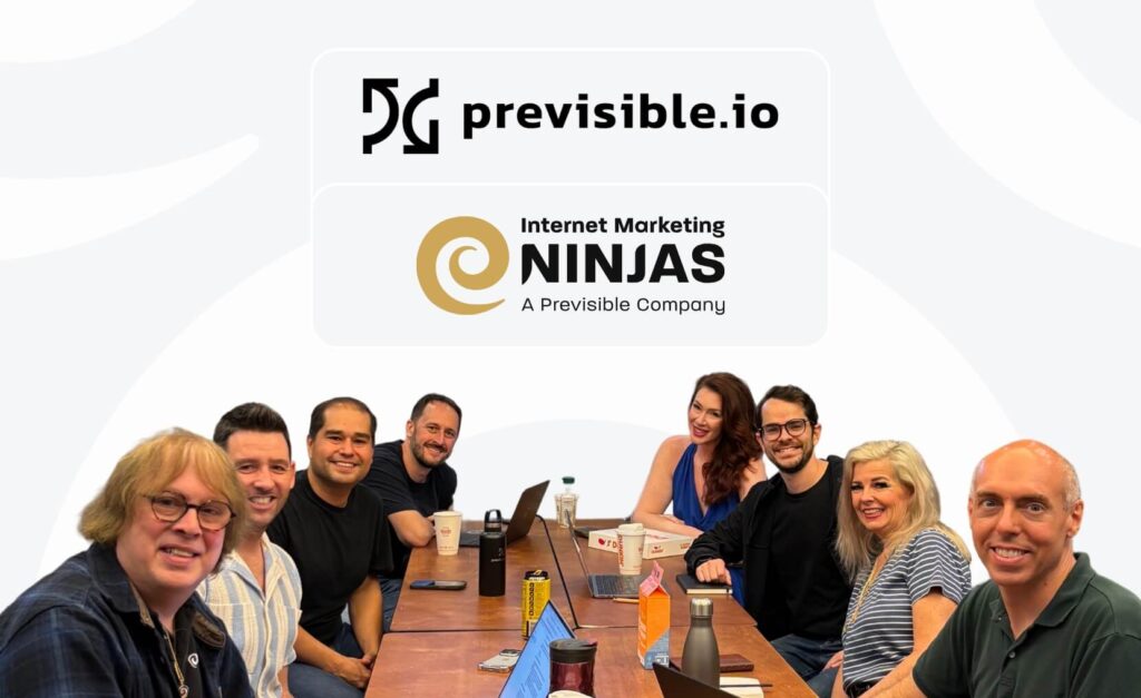 Eight people sit at a table with laptops and drinks, smiling at the camera. Behind them are logos for Previsible.io and Internet Marketing Ninjas, highlighting their collaboration in digital marketing.