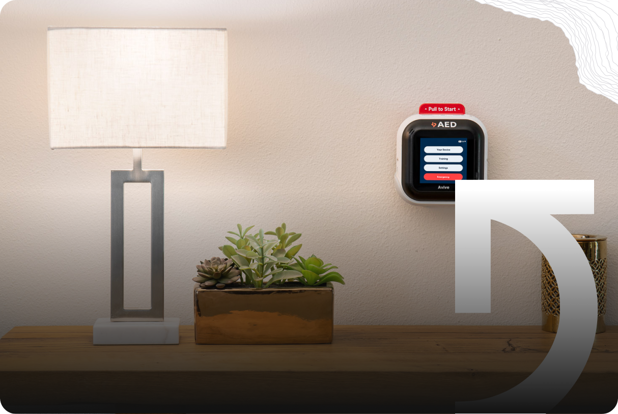 A table lamp and a rectangular planter with succulents sit on a wooden surface next to an AED device mounted on a wall, setting the scene for everyday success stories.